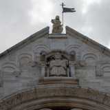 Poco pi� su, una figura enigmatica seduta in una nicchia scruta la piazza con un libro in mano, posta sotto la statuetta di Cristo Redentore. � il �sedente�: forse l�imperatore, il papa o un nobile locale